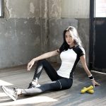 woman in black tank top and black leggings sitting on floor