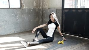 woman in black tank top and black leggings sitting on floor